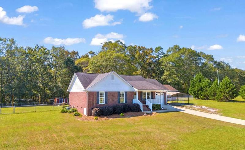 view marley pet sanctuary. Brick house with green lawn and forest in the back
